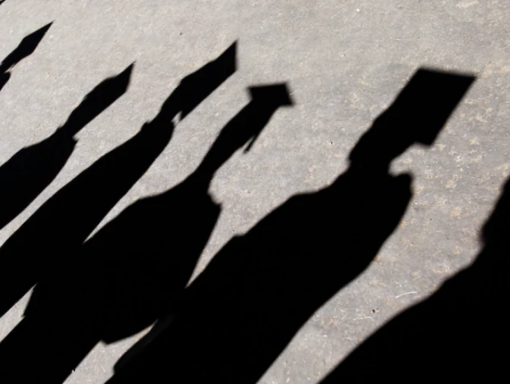 shadows of graduates walking in a line