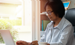 Older Asian woman looking at a laptop